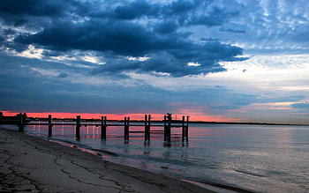 Sunset, blue, sand, pier, peaceful, sunrise, beauty, beach, waves, reflection, amazing, ocean, sea, beautiful, ocean waves, stormy, lights, view, clouds, nature, sky, lovely, splendor, storm HD wallpaper