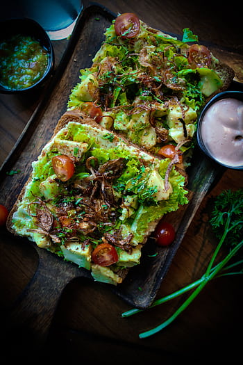 Delicious open sandwich with avocado, cherry tomatoes, and lettuce on a wooden board. HD phone wallpaper