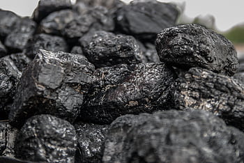 Detailed of dark, textured coal pieces in a close-up view, highlighting their rugged surface. HD wallpaper