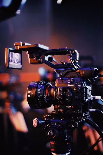 Close-up of a professional video camera setup indoors, capturing high-quality footage. HD phone wallpaper