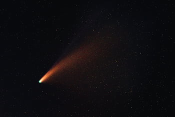A vibrant comet with a glowing tail traversing the starry night sky, showcasing the wonders of the universe. HD wallpaper