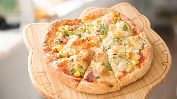 Fresh homemade vegetable pizza topped with cheese and served on a wooden board, perfect for a gourmet meal. HD wallpaper