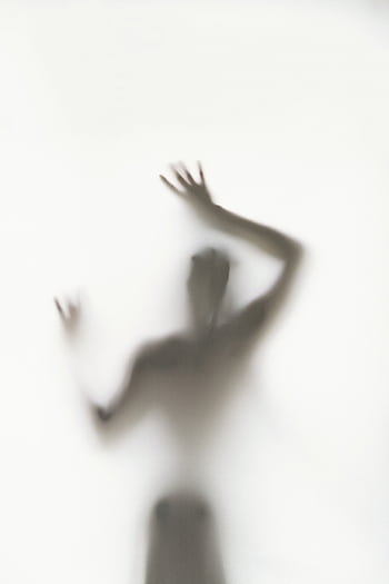 Blurry silhouette of a person with hands raised behind a frosted glass surface. HD phone wallpaper