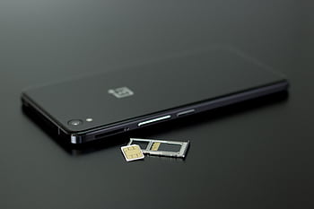 Close-up of a smart with a SIM card and memory card, showcasing modern technology. HD wallpaper