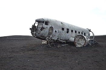A crashed aircraft wreckage in a deserted landscape, evoking mystery and history. HD wallpaper