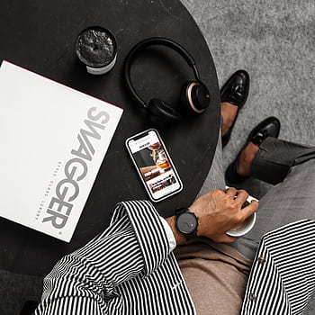 Top view of a stylish man with heads, smart, and swagger magazine on a round table. HD phone wallpaper