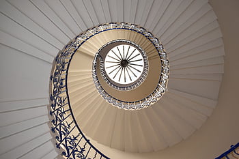 A captivating view up a spiral staircase with intricate railing design. HD wallpaper