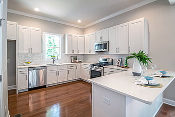 Spacious modern kitchen featuring white cabinets and appliances, perfect for home design. HD wallpaper