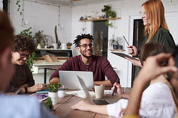 A diverse group of professionals engaging in a productive team meeting in a modern office space. HD wallpaper