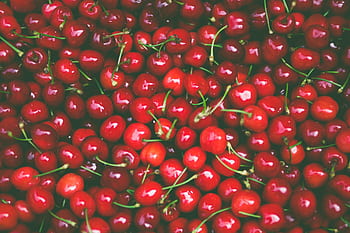 A vibrant pile of fresh red cherries showcasing vivid color and natural beauty. HD wallpaper