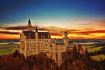 Breathtaking view of Neuschwanstein Castle in Germany during a vibrant sunset scene. HD wallpaper