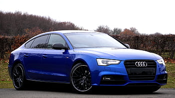 Elegant blue luxury car parked outdoors against a natural backdrop. HD wallpaper