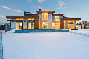 Contemporary luxury villa with modern design illuminated during winter with surrounding snow. HD wallpaper