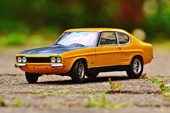 Detailed miniature Ford Capri model car with vibrant colors on an outdoor surface. HD wallpaper