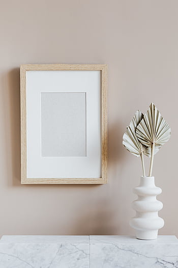 Elegant minimalist interior with a wooden frame and sculptural vase on a marble surface. HD phone wallpaper