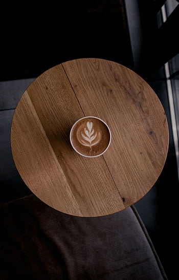 Top-down shot of a cappuccino with latte art on a wooden table, perfect for coffee lovers. HD phone wallpaper