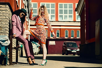 Stylish women posing in an urban alley showcasing contemporary fashion trends. HD wallpaper