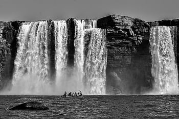 Stunning black and white capture of Chitrakote Falls with people rowing a boat HD wallpaper