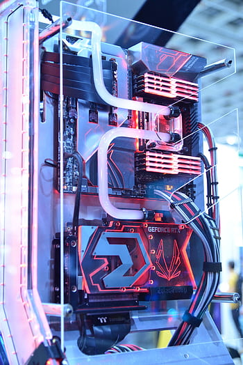 Close-up view of a custom gaming PC with water cooling and LED lights, highlighting advanced technology. HD phone wallpaper