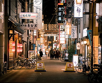Bustling evening scene of Osaka's vibrant shopping street with illuminated signs and people walking. HD wallpaper