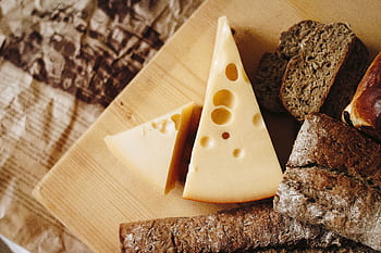 Close-up of cheese and rustic bread on a wooden board, ideal for culinary themes. HD wallpaper