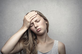 A woman in distress holding her head, expressing emotion and fatigue. HD wallpaper