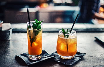 Two chilled cocktails with mint and ice on a bar counter, garnished with fresh mint leaves. HD wallpaper