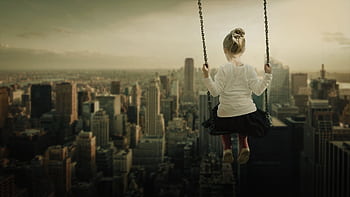A young girl on a swing set high above a bustling cityscape, capturing imagination and adventure. HD wallpaper