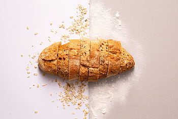 Freshly sliced whole grain bread with oats and flour provides a rustic and nutritious appeal. HD wallpaper