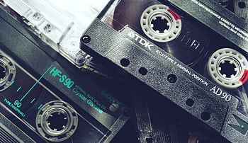 A nostalgic close-up of vintage cassette tapes showcasing 1980s audio technology and retro vibes. HD wallpaper