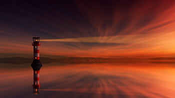 A stunning lighthouse silhouette during sunset reflecting in calm ocean waters. HD wallpaper