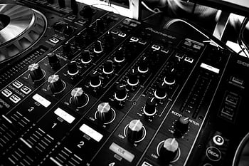 Black and white close-up of a DJ's audio mixing console with knobs and controls. HD wallpaper