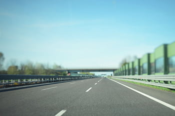 A straight highway stretches into the distance under a clear blue sky, ideal for travel concepts. HD wallpaper