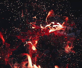 Dynamic close-up of red flames and sparks, showcasing intense heat and energy. HD wallpaper