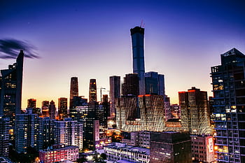 Vibrant cityscape of Beijing's skyline with illuminated skyscrapers at dusk. HD wallpaper