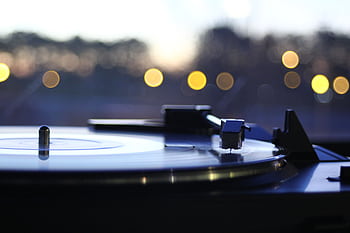 Close-up of a vintage turntable playing a vinyl record with a beautiful bokeh backdrop, capturing a nostalgic mood. HD wallpaper