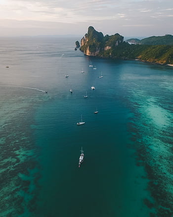 Breathtaking aerial view of Ao Nang Bay in Thailand, showcasing serene waters and sailboats. HD phone wallpaper