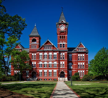 Front view of Samford Hall, Auburn University, with its iconic clock tower on a sunny day. HD wallpaper