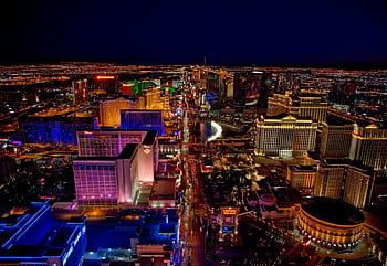 Stunning aerial view of Las Vegas Strip glowing at night with vibrant neon lights and bustling nightlife. HD wallpaper