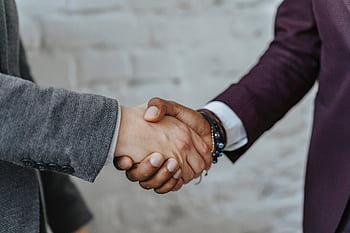 Professional handshake symbolizing cooperation and partnership in a business setting. HD wallpaper
