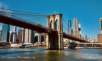 Stunning view of the Brooklyn Bridge and New York City skyline under clear blue skies. HD wallpaper