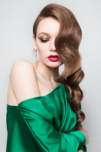 Stylish woman in an off-shoulder green dress, showcasing elegant hair and makeup. HD phone wallpaper