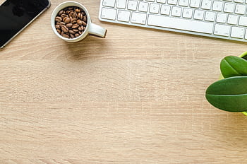 Flat lay of a clean desk with coffee beans, plant, smart, and keyboard. HD wallpaper