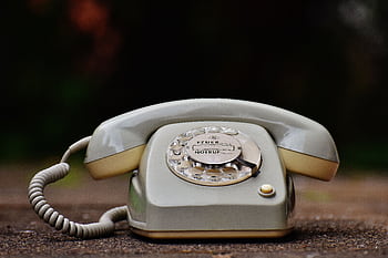 Close-up of a vintage rotary dial tele with a nostalgic design on a wooden surface. HD wallpaper