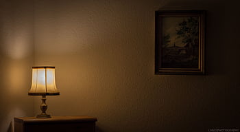 Warmly lit room with a vintage lamp and framed painting on the wall. HD wallpaper