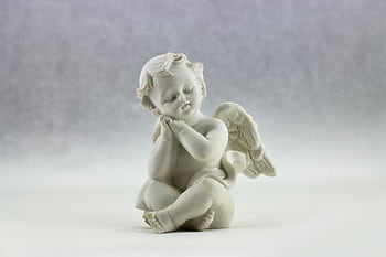 A cute ceramic angel figurine in a serene pose, perfect for decorative art displays. HD wallpaper