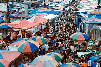 A bustling street market in Manila with colorful tents and a lively crowd shopping outdoors. HD wallpaper