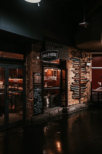 Evening view of Cull & Pistol restaurant exterior with illuminated signage in New York City. HD phone wallpaper