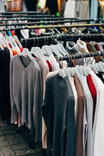 A collection of colorful clothing on racks in a retail store setting. HD phone wallpaper