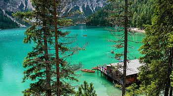 Scenic view of a tranquil alpine lake surrounded by trees and mountains, perfect for relaxation. HD wallpaper